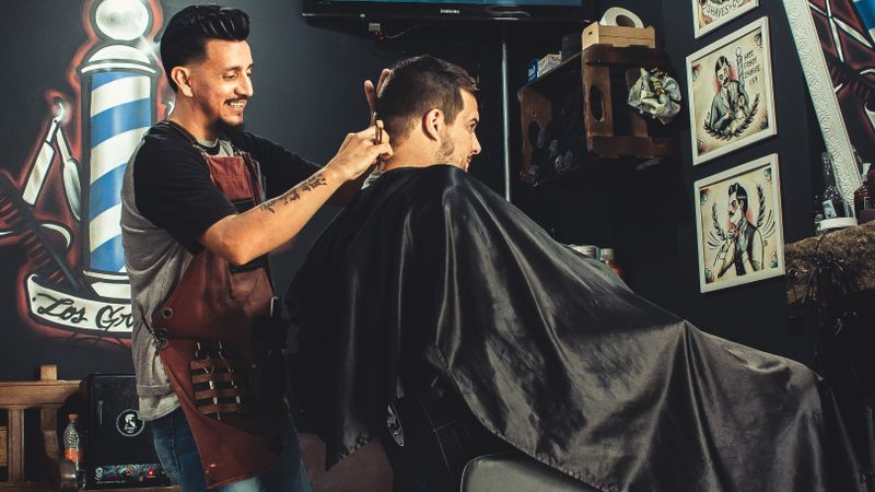 Barbeiro cortando o cabelo de um cliente em uma barbearia